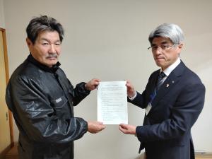 協定書を手渡す産業部長と受け取る組合長