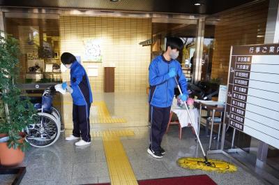 市役所玄関を清掃する生徒達