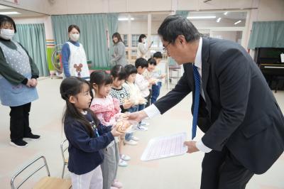 米津社長からパンを受け取る園児たち