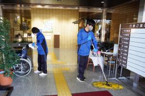 市役所玄関を清掃する生徒達